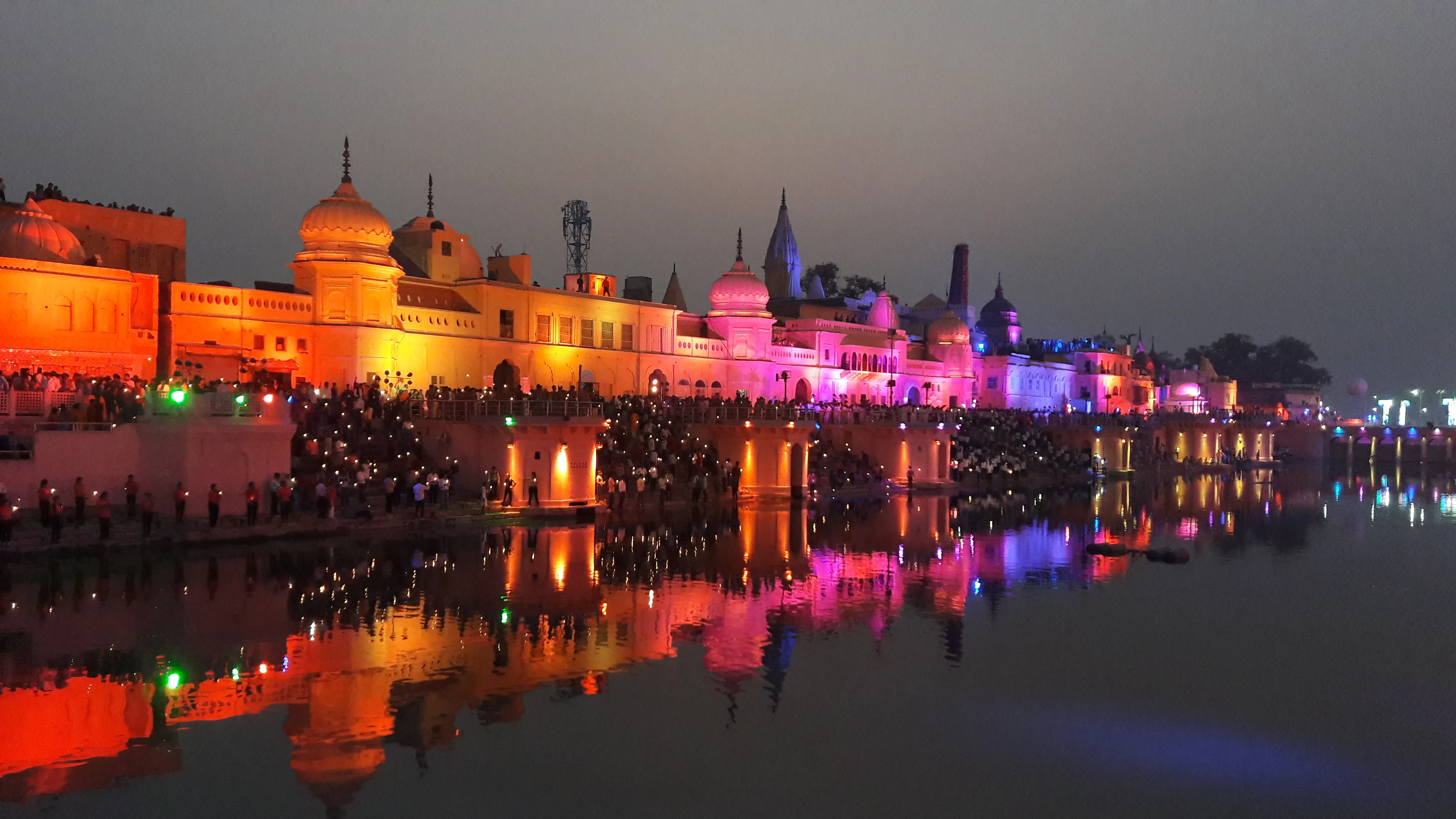 Ram Ki Paidi at twilight: the lit ghats of the Sarayu river at Ayodhya, with the temple skyline reflected in the water